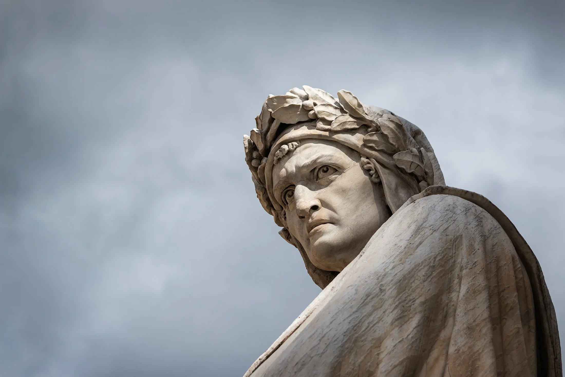 Close-up shot of the famous white marble monument of Dante Alighieri by Enrico Pazzi in Piazza Santa Croce, next to Basilica of Santa Croce, Florence, Italy. (Shutterstock Photo)